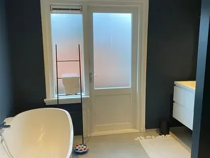 Maatwerk sanitair en tegelwerk in een gerenoveerde badkamer.