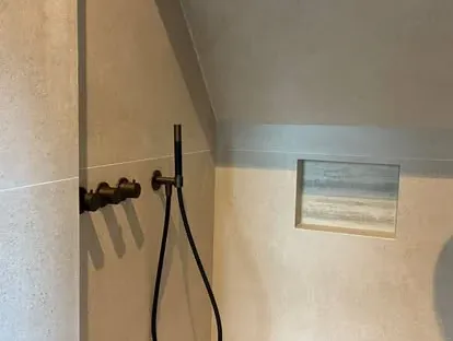 Badkamerrenovatie met zorgvuldig afgestemd sanitair, tegelwerk en verlichting.