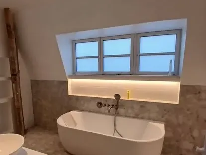 Badkamerrenovatie met zorgvuldig afgestemd sanitair, tegelwerk en verlichting.