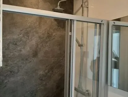Badkamerrenovatie met zorgvuldig afgestemd sanitair, tegelwerk en verlichting.