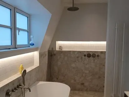Badkamerrenovatie met zorgvuldig afgestemd sanitair, tegelwerk en verlichting.