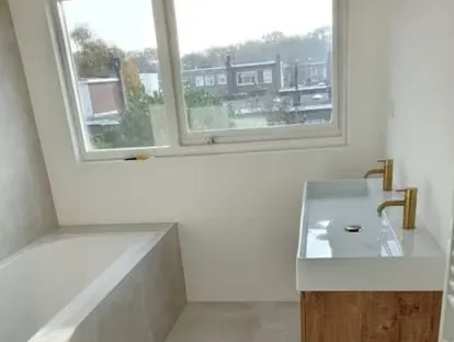 Badkamerrenovatie met zorgvuldig afgestemd sanitair, tegelwerk en verlichting.