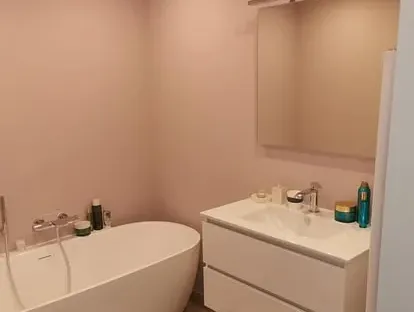 Badkamerrenovatie met zorgvuldig afgestemd sanitair, tegelwerk en verlichting.