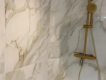 Maatwerk sanitair en tegelwerk in een gerenoveerde badkamer.