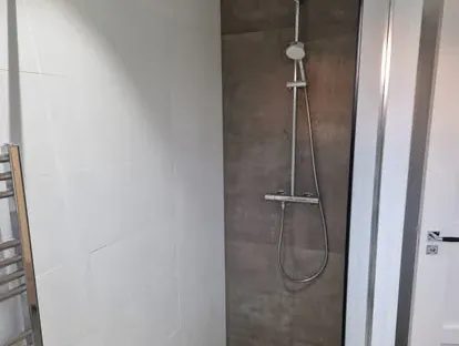 Badkamerrenovatie met zorgvuldig afgestemd sanitair, tegelwerk en verlichting.