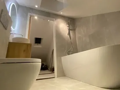 Badkamerrenovatie met zorgvuldig afgestemd sanitair, tegelwerk en verlichting.