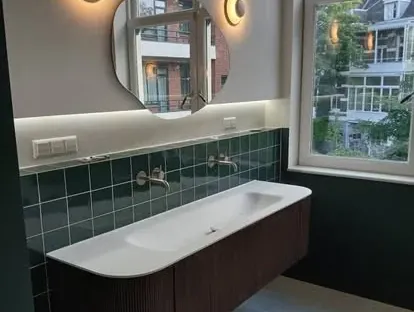 Badkamerrenovatie met zorgvuldig afgestemd sanitair, tegelwerk en verlichting.
