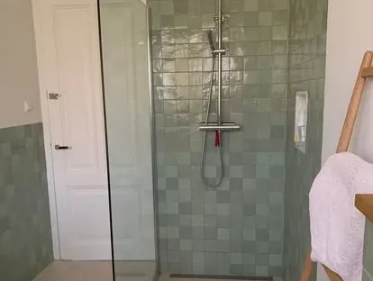 Maatwerk sanitair en tegelwerk in een gerenoveerde badkamer.