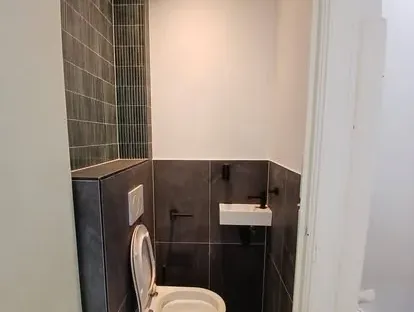 Badkamerrenovatie met zorgvuldig afgestemd sanitair, tegelwerk en verlichting.