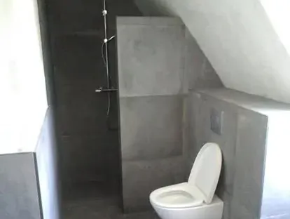 Maatwerk sanitair en tegelwerk in een gerenoveerde badkamer.