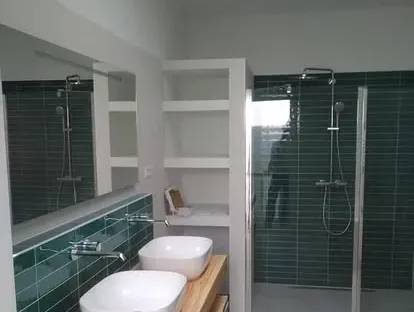Badkamerrenovatie met zorgvuldig afgestemd sanitair, tegelwerk en verlichting.
