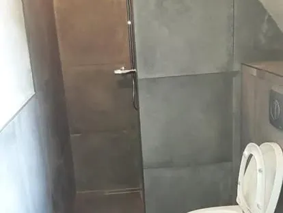 Badkamerrenovatie met zorgvuldig afgestemd sanitair, tegelwerk en verlichting.