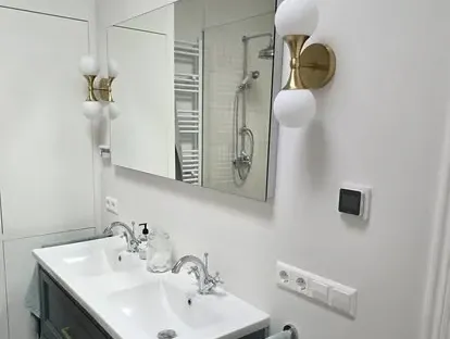 Badkamerrenovatie met zorgvuldig afgestemd sanitair, tegelwerk en verlichting.