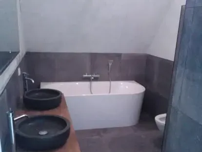 Maatwerk sanitair en tegelwerk in een gerenoveerde badkamer.