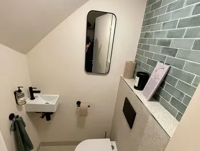 Maatwerk sanitair en tegelwerk in een gerenoveerde badkamer.