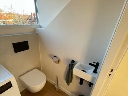 Badkamerrenovatie met zorgvuldig afgestemd sanitair, tegelwerk en verlichting.