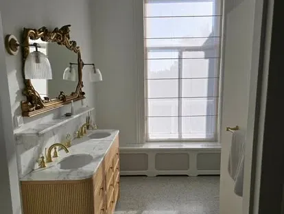Badkamerrenovatie met zorgvuldig afgestemd sanitair, tegelwerk en verlichting.