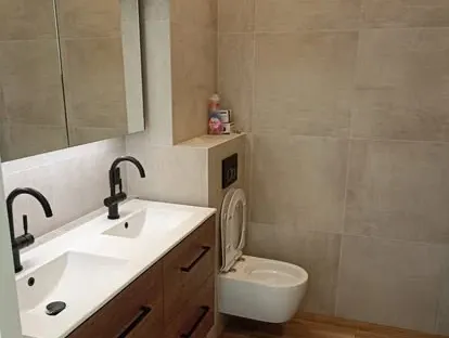 Maatwerk sanitair en tegelwerk in een gerenoveerde badkamer.