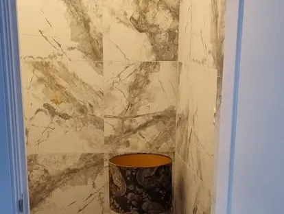 Badkamerrenovatie met zorgvuldig afgestemd sanitair, tegelwerk en verlichting.