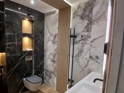 Badkamerrenovatie met zorgvuldig afgestemd sanitair, tegelwerk en verlichting.