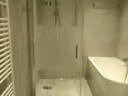 Badkamerrenovatie met zorgvuldig afgestemd sanitair, tegelwerk en verlichting.