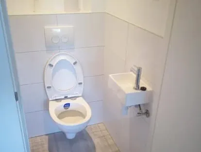 Badkamerrenovatie met zorgvuldig afgestemd sanitair, tegelwerk en verlichting.