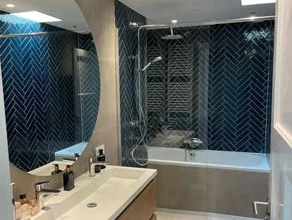 Maatwerk sanitair en tegelwerk in een gerenoveerde badkamer.