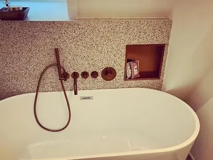 Maatwerk sanitair en tegelwerk in een gerenoveerde badkamer.