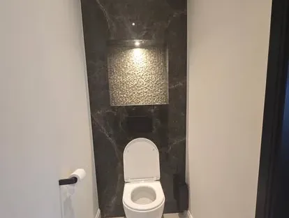 Badkamerrenovatie met zorgvuldig afgestemd sanitair, tegelwerk en verlichting.
