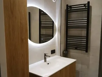 Badkamerrenovatie met zorgvuldig afgestemd sanitair, tegelwerk en verlichting.
