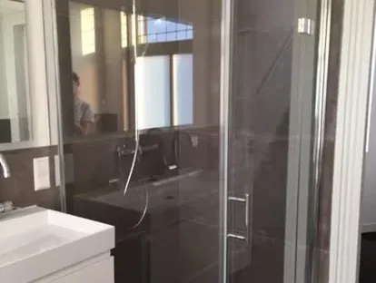 Badkamerrenovatie met zorgvuldig afgestemd sanitair, tegelwerk en verlichting.