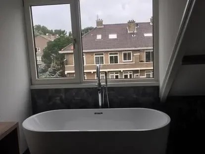 Badkamerrenovatie met zorgvuldig afgestemd sanitair, tegelwerk en verlichting.
