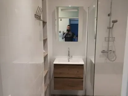 Badkamerrenovatie met zorgvuldig afgestemd sanitair, tegelwerk en verlichting.