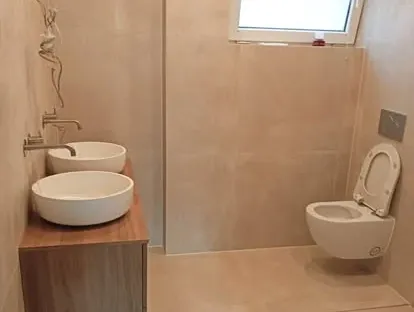 Badkamerrenovatie met zorgvuldig afgestemd sanitair, tegelwerk en verlichting.