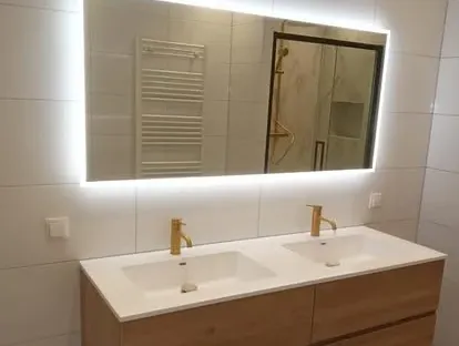 Badkamerrenovatie met zorgvuldig afgestemd sanitair, tegelwerk en verlichting.