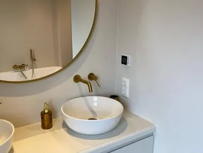 Badkamerrenovatie met zorgvuldig afgestemd sanitair, tegelwerk en verlichting.