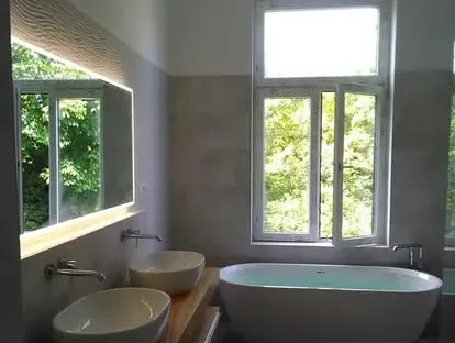 Badkamerrenovatie met zorgvuldig afgestemd sanitair, tegelwerk en verlichting.