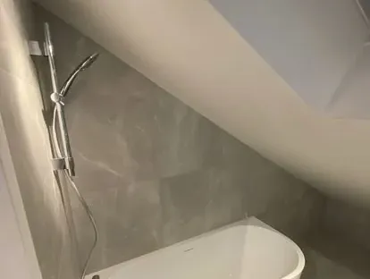 Maatwerk sanitair en tegelwerk in een gerenoveerde badkamer.