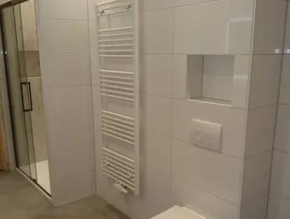Maatwerk sanitair en tegelwerk in een gerenoveerde badkamer.