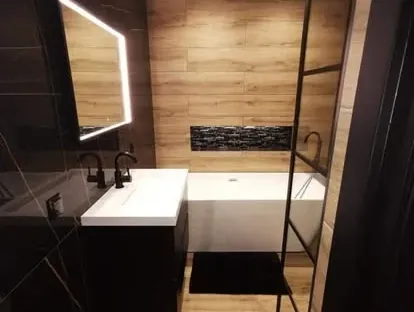 Badkamerrenovatie met zorgvuldig afgestemd sanitair, tegelwerk en verlichting.