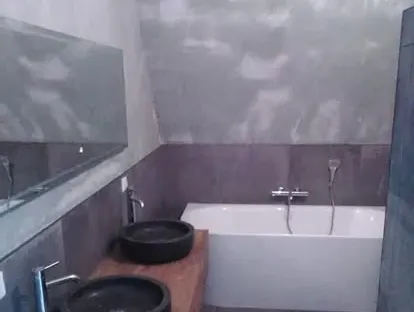 Maatwerk sanitair en tegelwerk in een gerenoveerde badkamer.