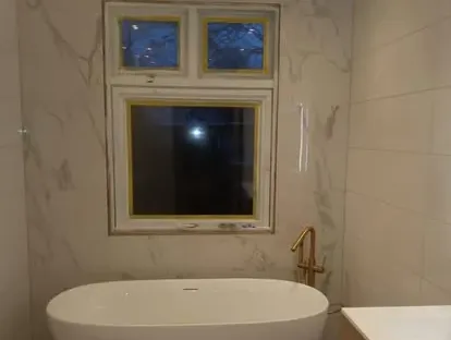 Maatwerk sanitair en tegelwerk in een gerenoveerde badkamer.
