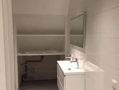 Maatwerk sanitair en tegelwerk in een gerenoveerde badkamer.