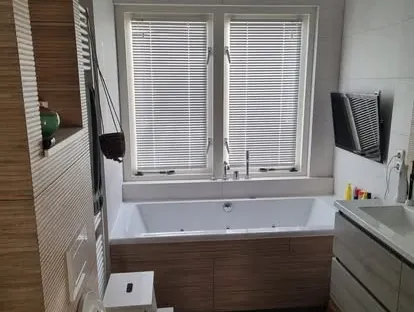 Maatwerk sanitair en tegelwerk in een gerenoveerde badkamer.
