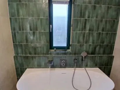 Maatwerk sanitair en tegelwerk in een gerenoveerde badkamer.