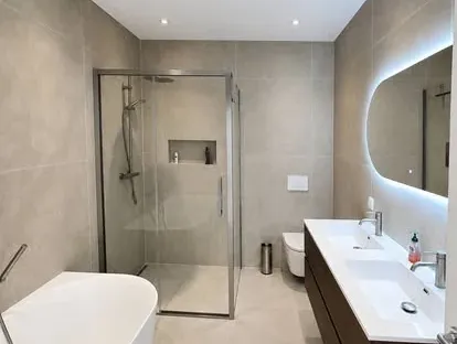 Maatwerk sanitair en tegelwerk in een gerenoveerde badkamer.