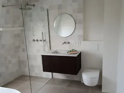 Maatwerk sanitair en tegelwerk in een gerenoveerde badkamer.