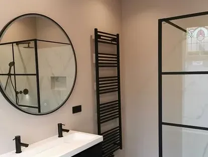 Badkamerrenovatie met zorgvuldig afgestemd sanitair, tegelwerk en verlichting.
