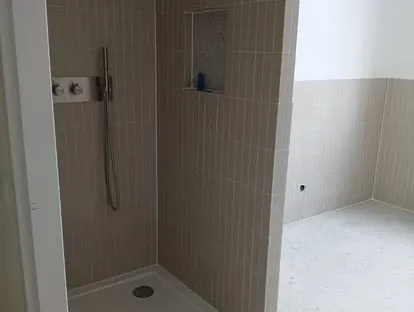 Badkamerrenovatie met zorgvuldig afgestemd sanitair, tegelwerk en verlichting.