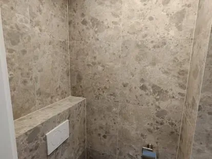 Maatwerk sanitair en tegelwerk in een gerenoveerde badkamer.